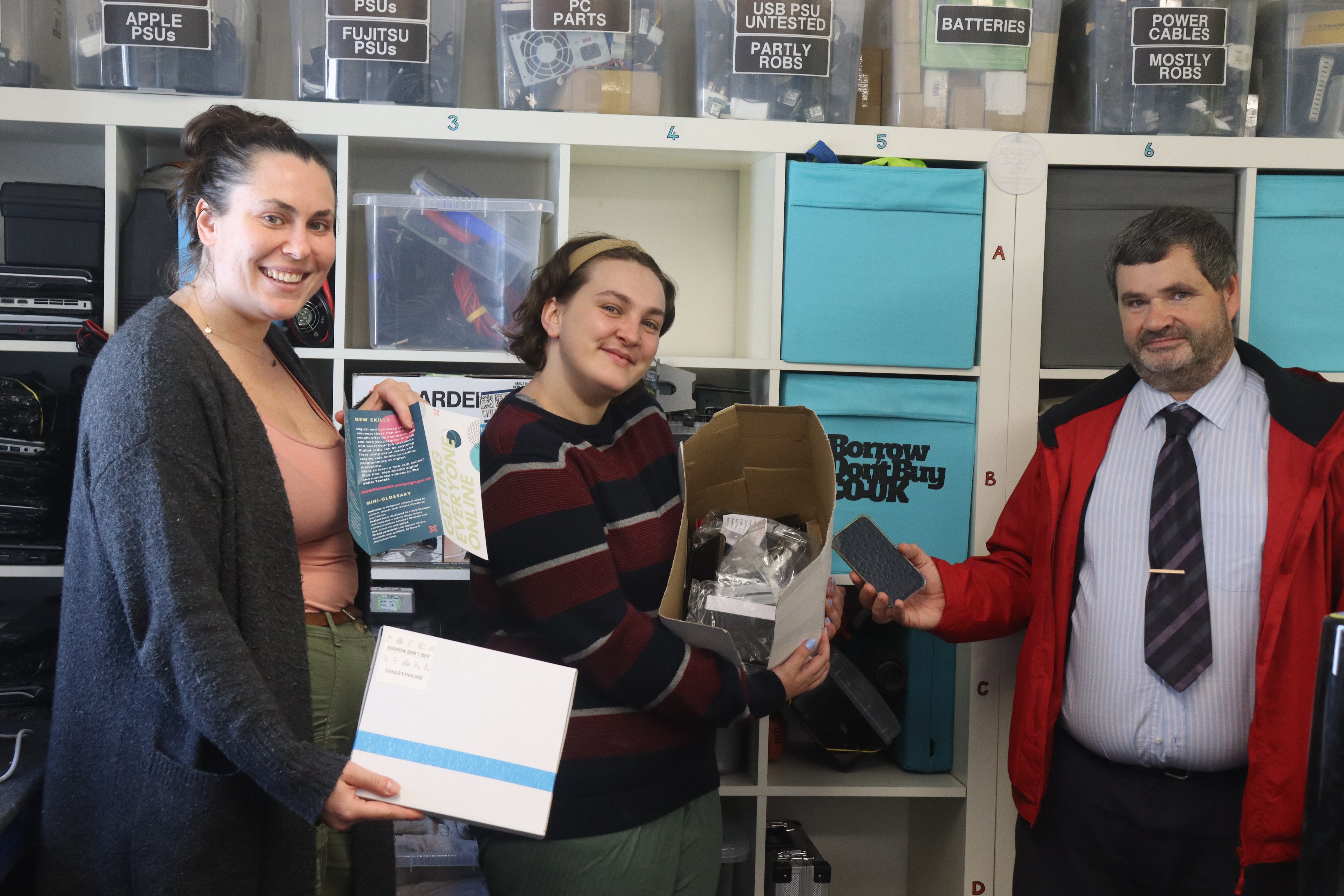 Borrow Don't Buy 'elves' Esther Scali and Mia Ward-Edwards receiving a mobile phone donation from Plymouth Citybus' Jason Beverly